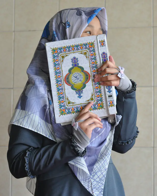 Woman holding the Holy Quran close